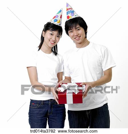 Teens with peaked hat giving birthday gift View Large Photo Image Stock Image - Teens with peaked hat giving birthday gift . Fotosearch
