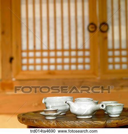 Stock Image - Green tea set in front of Oriental window, art of tea making. Fotosearch