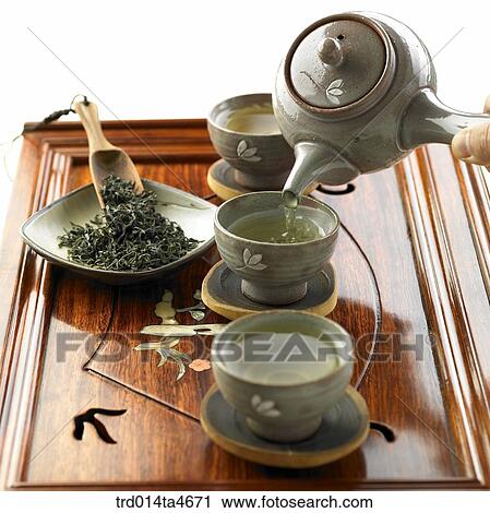 Tea cups with green tea on the teatray, tea digger and green tea leaves, art of tea making View Large Photo Image Stock Image - Tea cups with green tea on the teatray, tea digger and green tea leaves, art of tea making. Fotosearch