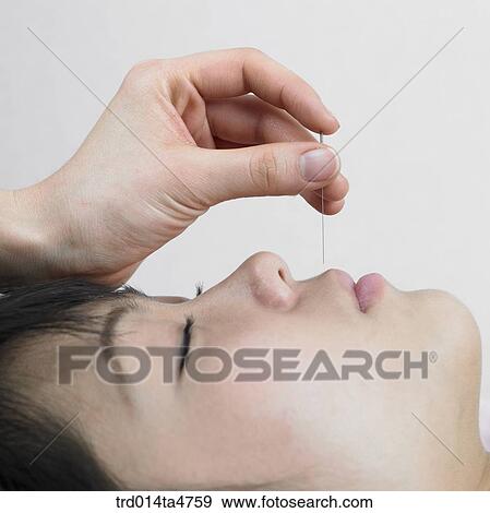 Stock Photo - Chinese medicine oriental medicine/hand applying accupuntue on patient's face. Fotosearch
