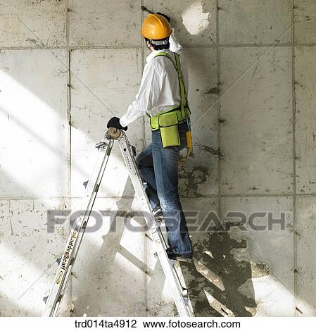 at a construction place, a worker working on a ladder View Large Photo Image Stock Image - at a construction place, a worker working on a ladder. Fotosearch