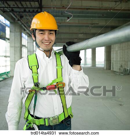 at a construction place, a worker holding a reinforcing rod on the shoulder View Large Photo Image Stock Image - at a construction place, a worker holding a reinforcing rod on the shoulder. Fotosearch