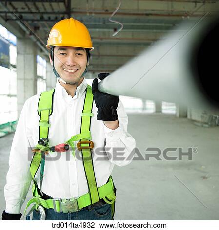 at a construction place, a worker holding a reinforcing rod on the shoulder View Large Photo Image Stock Image - at a construction place, a worker holding a reinforcing rod on the shoulder. Fotosearch