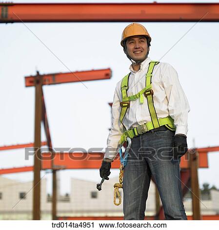 at a construction place, a worker looking around a workplace View Large Photo Image Stock Image - at a construction place, a worker looking around a workplace. Fotosearch