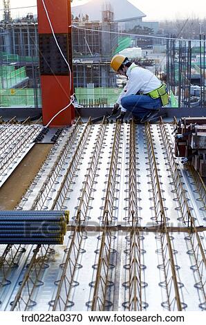 Stock Image - at a construction place, a worker. Fotosearch