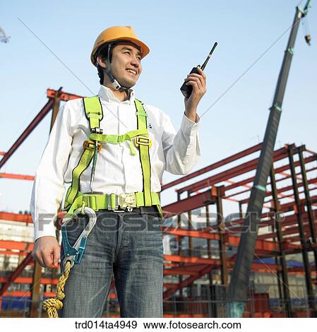 at a construction place, a worker holding a radiotelegraph View Large Photo Image Stock Photo - at a construction place, a worker holding a radiotelegraph. Fotosearch