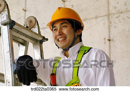at a construction place, a worker leaning on a ladder View Large Photo Image Stock Photography - at a construction place, a worker leaning on a ladder. Fotosearch