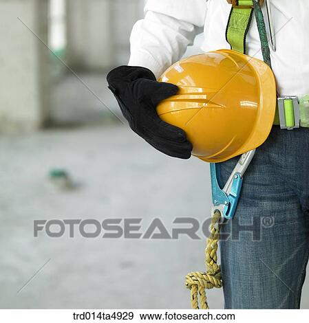 at a construction place, a worker's hand holding a safety hand View Large Photo Image Stock Photo - at a construction place, a worker's hand holding a safety hand. Fotosearch