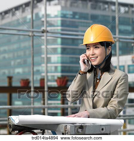 at a construction place, an architect talking on the phone View Large Photo Image Picture - at a construction place, an architect talking on the phone. Fotosearch