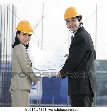 at a construction place, an architect holding a plan View Large Photo Image Stock Image - at a construction place, an architect holding a plan. Fotosearch