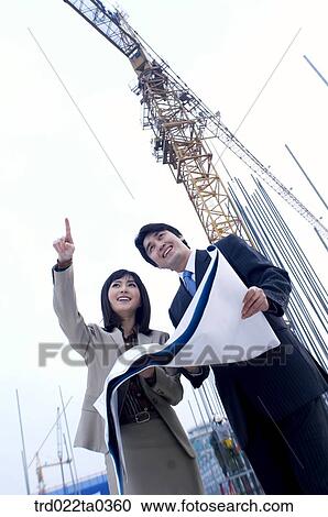 Stock Image - at a construction place, an architect looking around a workplace. Fotosearch