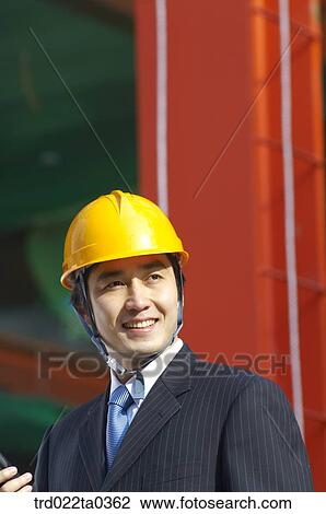 Stock Image - at a construction place, an architect looking around a workplace. Fotosearch