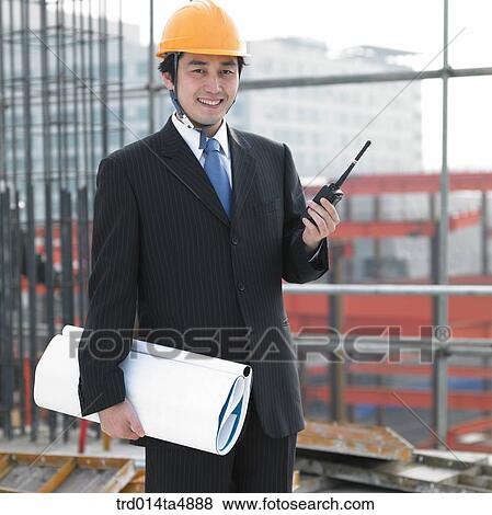 at a construction place, an architect holding a radiotelegraph and a plan View Large Photo Image Stock Photo - at a construction place, an architect holding a radiotelegraph and a plan. Fotosearch
