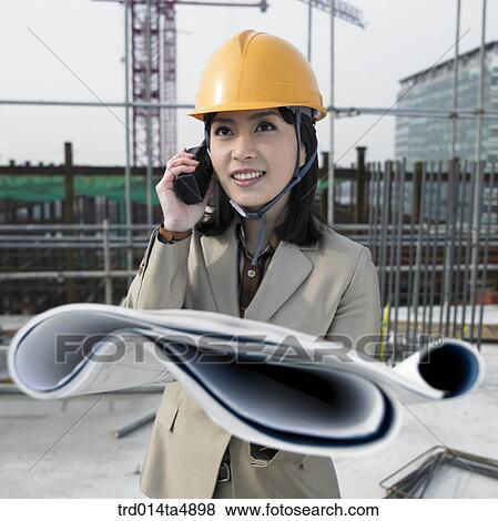 at a construction place, an architect looking at a plan and talking with a radiotelegraph View Large Photo Image Stock Photo - at a construction place, an architect looking at a plan and talking with a radiotelegraph. Fotosearch
