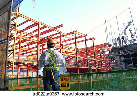 at a construction place, an architect looking at a plan View Large Photo Image Stock Photo - at a construction place, an architect looking at a plan. Fotosearch