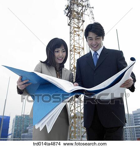 at a construction place, architects looking at a plan View Large Photo Image Picture - at a construction place, architects looking at a plan. Fotosearch