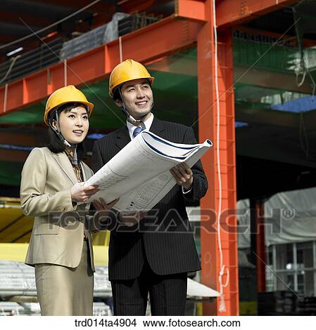 at a construction place, architects looking at a plan View Large Photo Image Picture - at a construction place, architects looking at a plan. Fotosearch