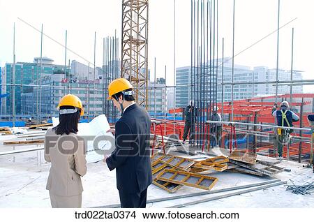 at a construction place, architects looking at a plan View Large Photo Image Picture - at a construction place, architects looking at a plan. Fotosearch