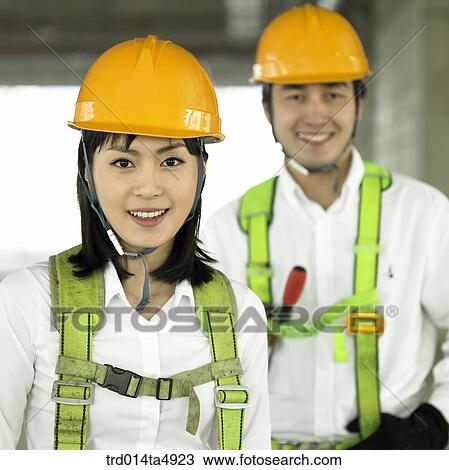 Stock Image - at a construction place, architects with safey equipment. Fotosearch