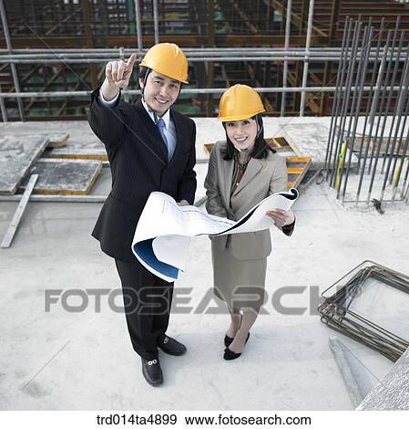 Stock Photo - at a construction place, architects discussing about a plan. Fotosearch