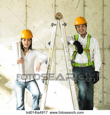 at a construction place, architects holding a plan View Large Photo Image Stock Photo - at a construction place, architects holding a plan. Fotosearch