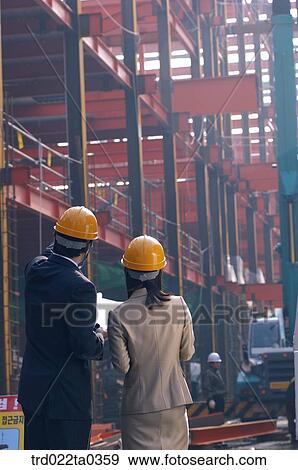 Stock Photo - at a construction place, architects looking around a workplace. Fotosearch