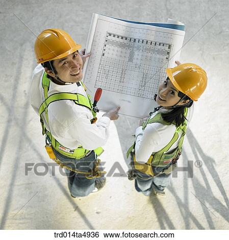 at a construction place, architects holding a plan View Large Photo Image Stock Photograph - at a construction place, architects holding a plan. Fotosearch