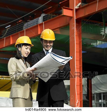 Stock Photography - at a construction place, architects looking at a plan. Fotosearch