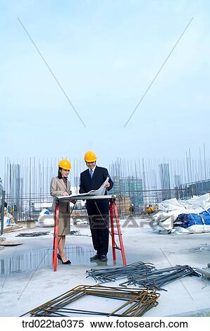 Stock Photography - at a construction place, architects looking at a plan. Fotosearch
