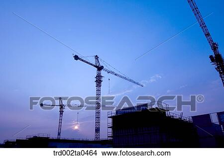 at a construction place, a crane in the evening View Large Photo Image Picture - at a construction place, a crane in the evening. Fotosearch