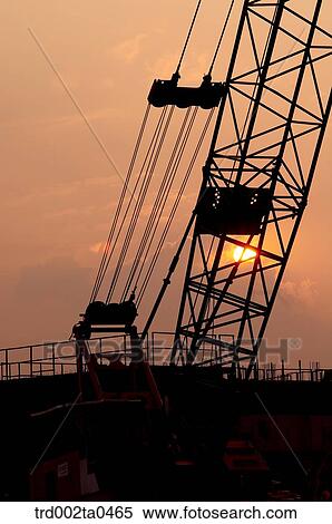 at a construction place, a crane with the glow of the setting sun View Large Photo Image Stock Photography - at a construction place, a crane with the glow of the setting sun. Fotosearch