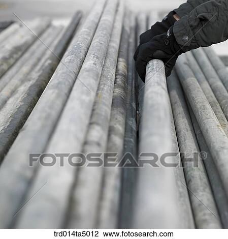 Stock Image - at a construction place, construction equipments and a worker's hand. Fotosearch