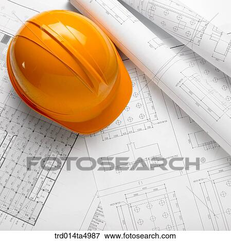 Stock Photo - construction, a plan and a safety hat on a desk. Fotosearch