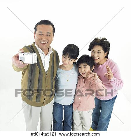 Stock Image - Family/ a family taking pictures with a digital camera. Fotosearch