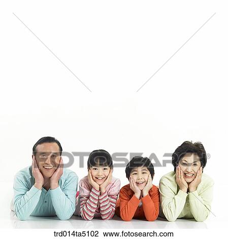 Stock Image - Family/ a family with their chins resting on the hand lying prone. Fotosearch
