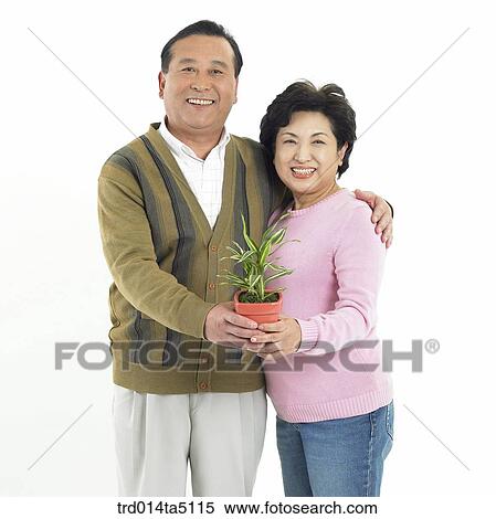 Family/ A friendly family holding a flowerpot View Large Photo Image Stock Photography - Family/ A friendly family holding a flowerpot. Fotosearch