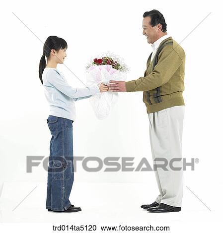 Family/ a granddaughter giving a bouquet to her grandfather View Large Photo Image Stock Image - Family/ a granddaughter giving a bouquet to her grandfather. Fotosearch