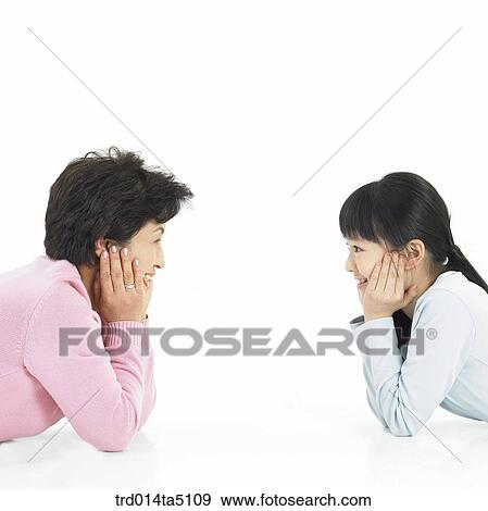 Family/ a grandmother and her granddauther with their chins resting on the hand facing each other View Large Photo Image Stock Photo - Family/ a grandmother and her granddauther with their chins resting on the hand facing each other. Fotosearch