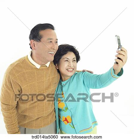 Family/ an friendly old couple taking pictures by a mobile phone View Large Photo Image Stock Image - Family/ an friendly old couple taking pictures by a mobile phone. Fotosearch