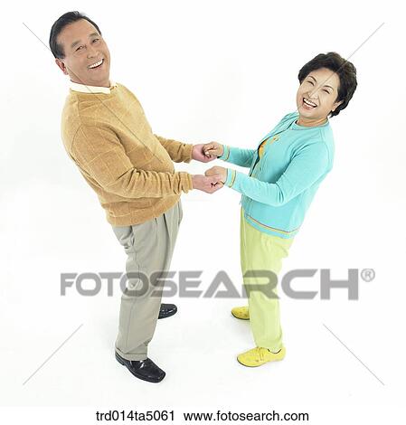 Stock Image - Family/ an friendly old couple taking by the hand. Fotosearch