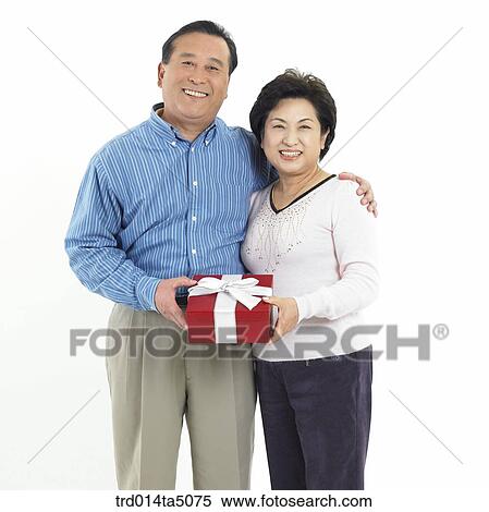 Stock Photography - Family/ an old couple holding a present. Fotosearch