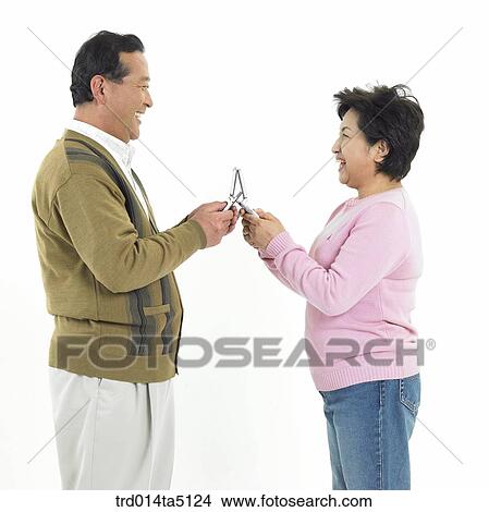 Family/ an old couple holding their mobile phones View Large Photo Image Picture - Family/ an old couple holding their mobile phones. Fotosearch