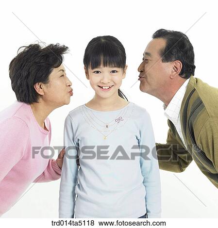 Stock Photo - Family/ grandparents kissing their granddaughter. Fotosearch