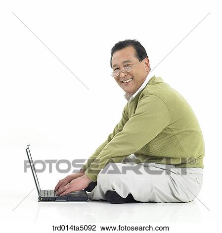Stock Image - The old/ a sitting man working with a notebook. Fotosearch