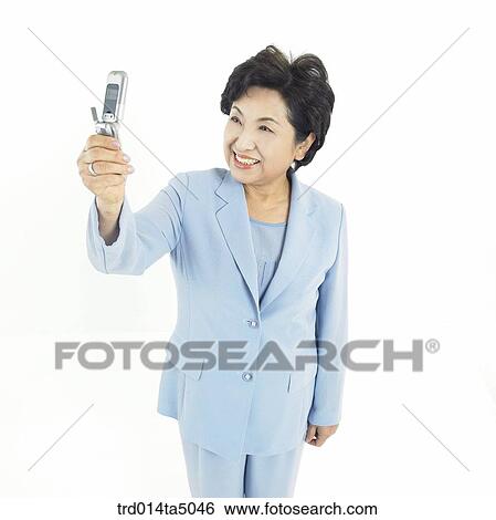 The old/ A woman holding a mobile phone View Large Photo Image Stock Photograph - The old/ A woman holding a mobile phone. Fotosearch