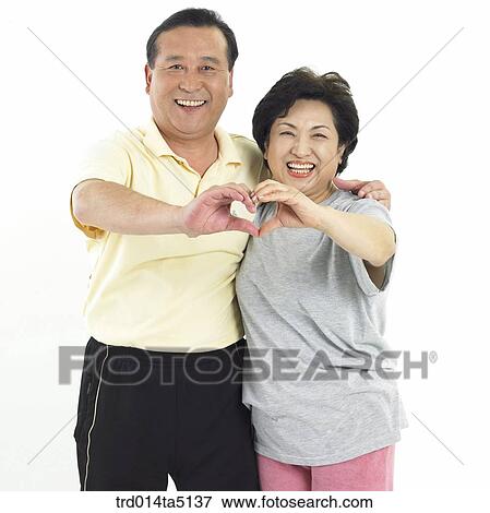 Stock Photo - The old/ an old couple drawing heart in the air. Fotosearch