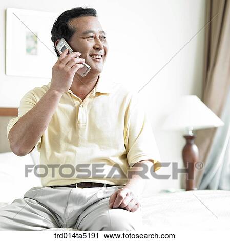 Stock Image - a calling old man on a bed. Fotosearch