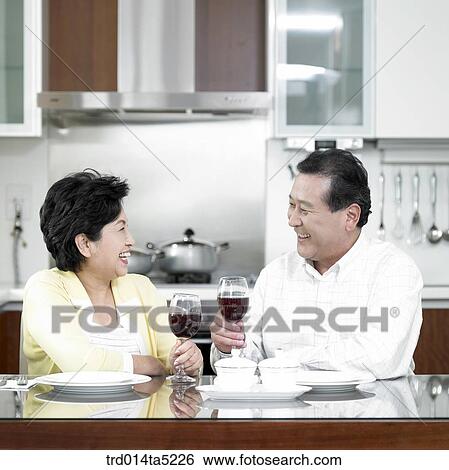 an old couple drinking wine at a kitchen View Large Photo Image Stock Photograph - an old couple drinking wine at a kitchen. Fotosearch