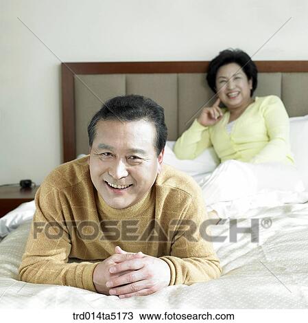 Stock Image - an old couple on a bed. Fotosearch