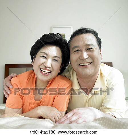 Stock Image - an old couple on a bed. Fotosearch